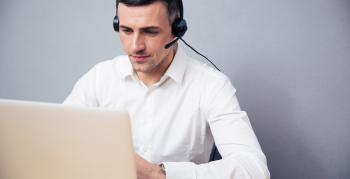 Man with a headset on sitting at a computer